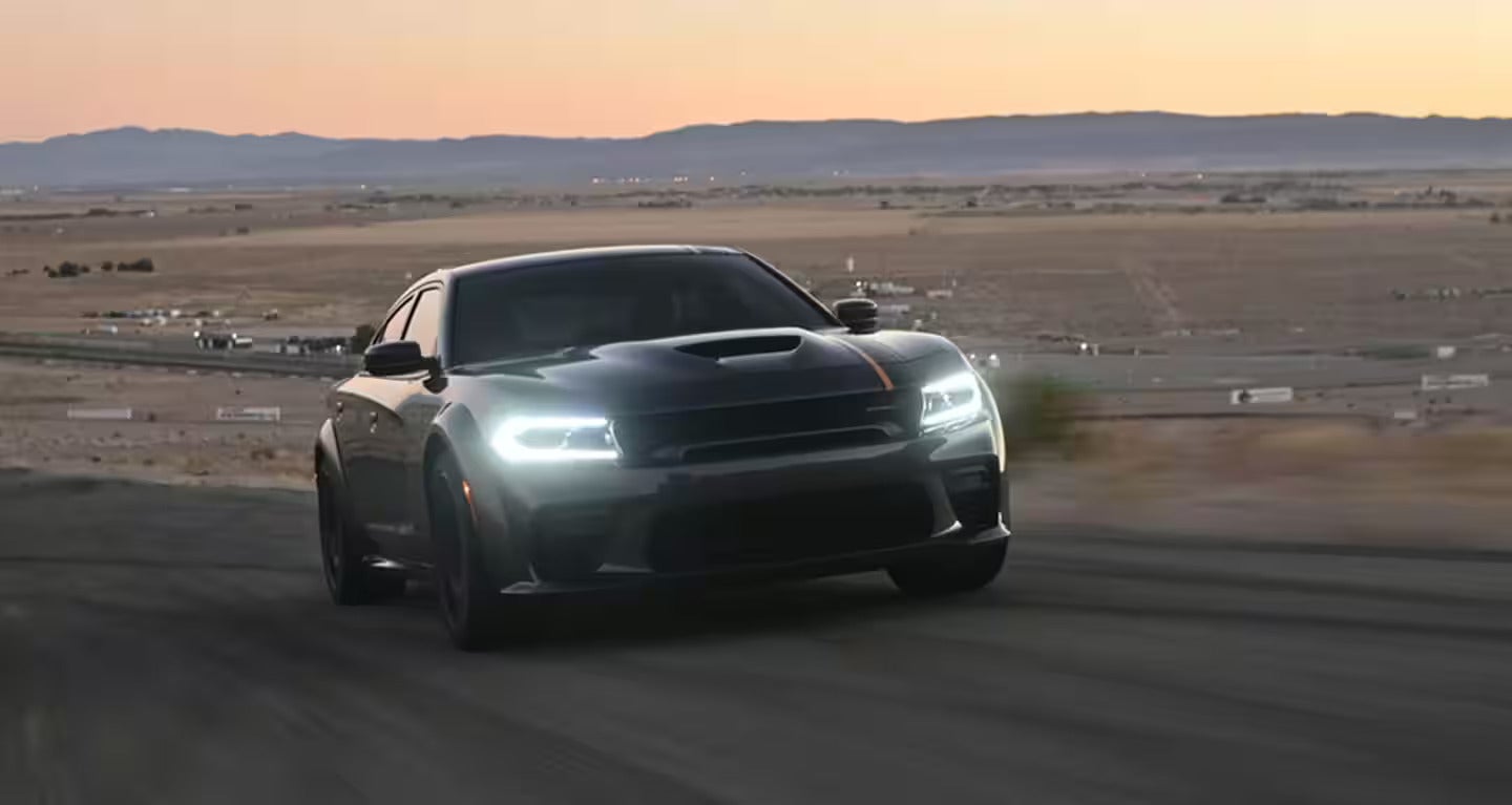 a 2023 dodge charger parked on the road after sunset