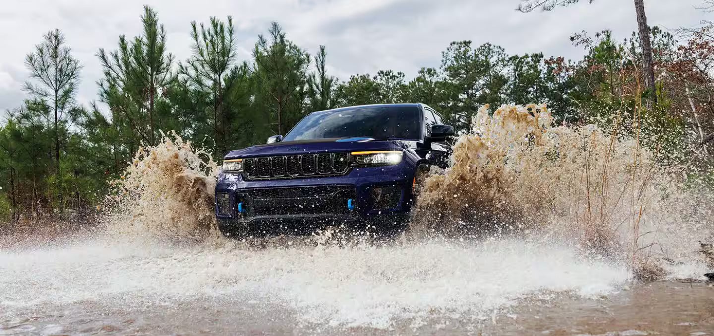a blue suv going through muddy water