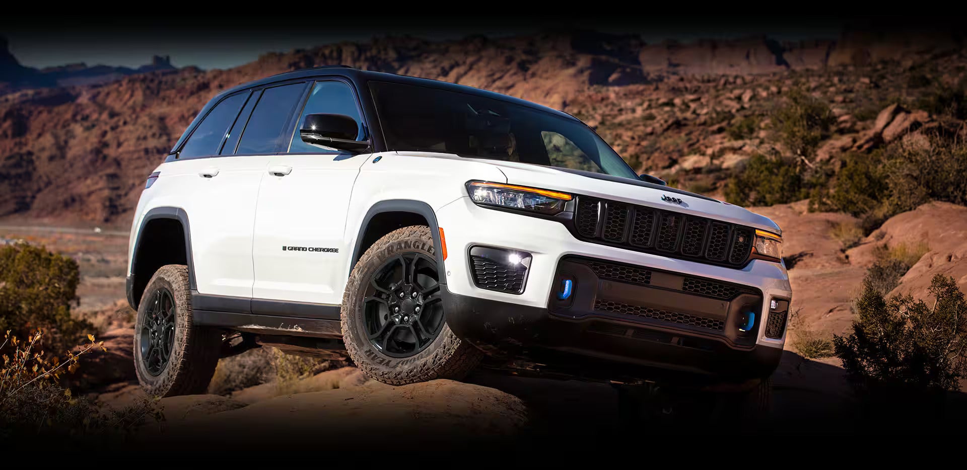 a white suv driving over rocks